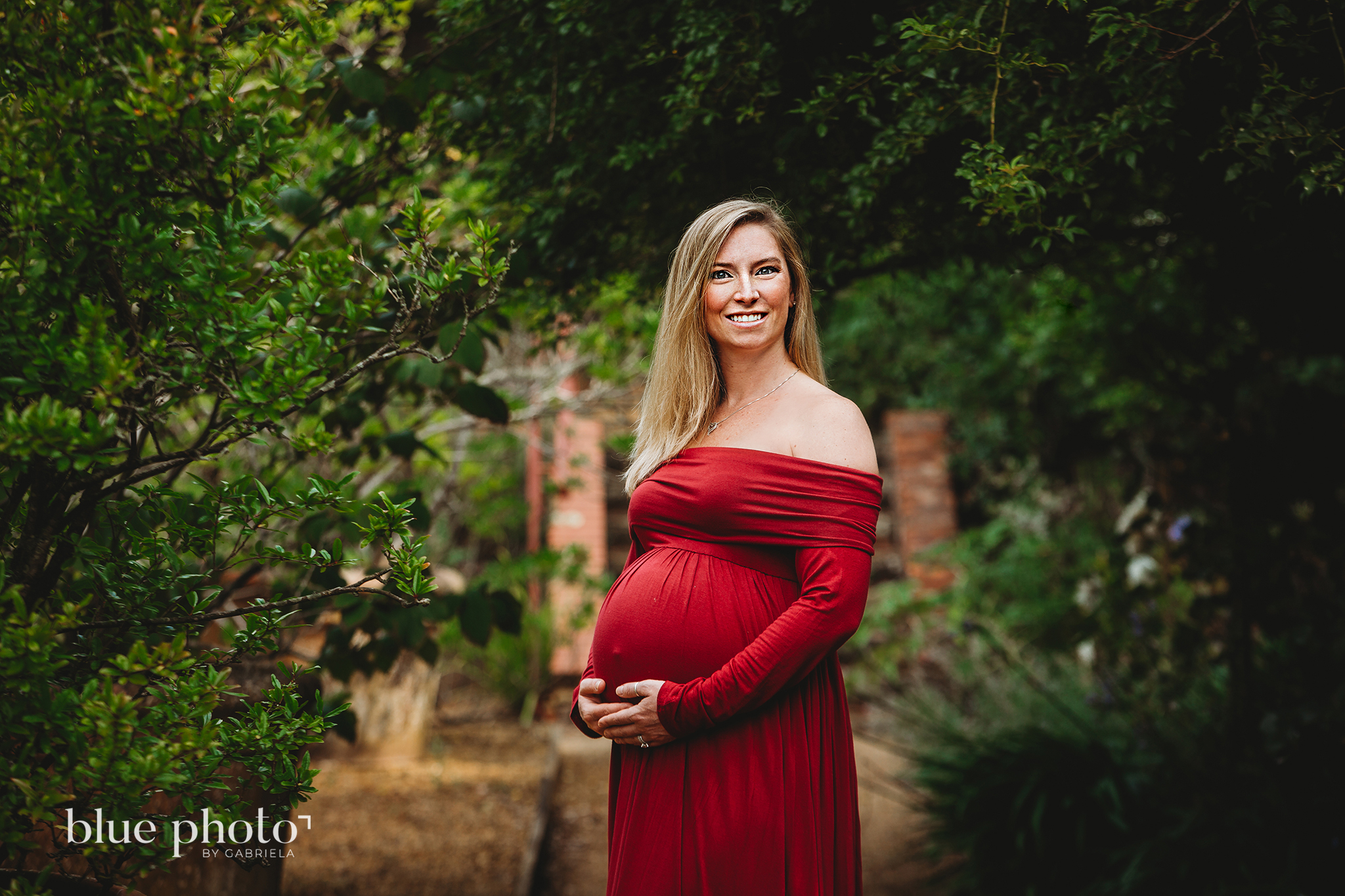 Maternity session in North London, a pregnant woman in red dress is possing in The Hill and Pergola Garden