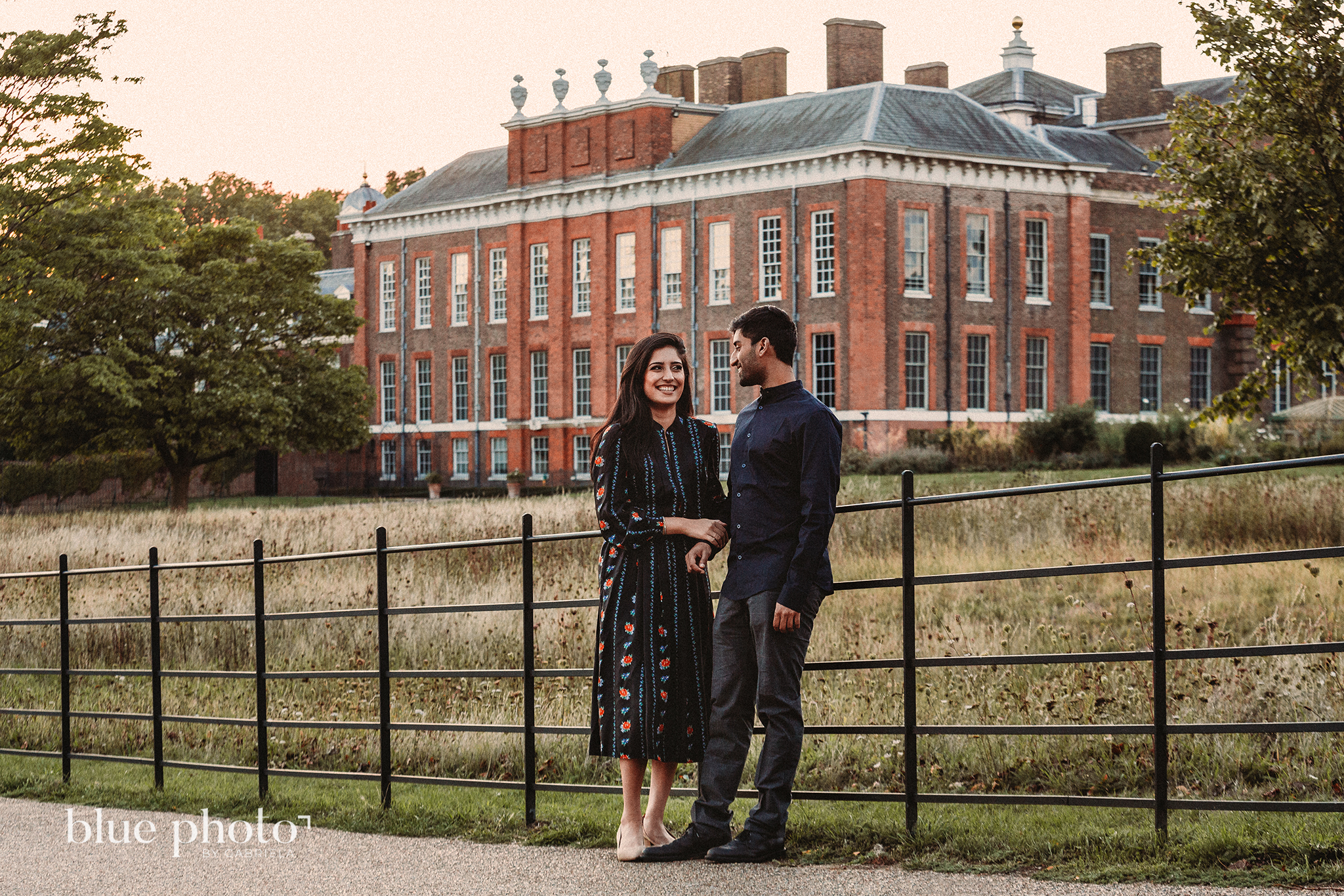 Engagement session in Kensingtom Gardens, Central London. A couple is looking at each other and smilling.  
