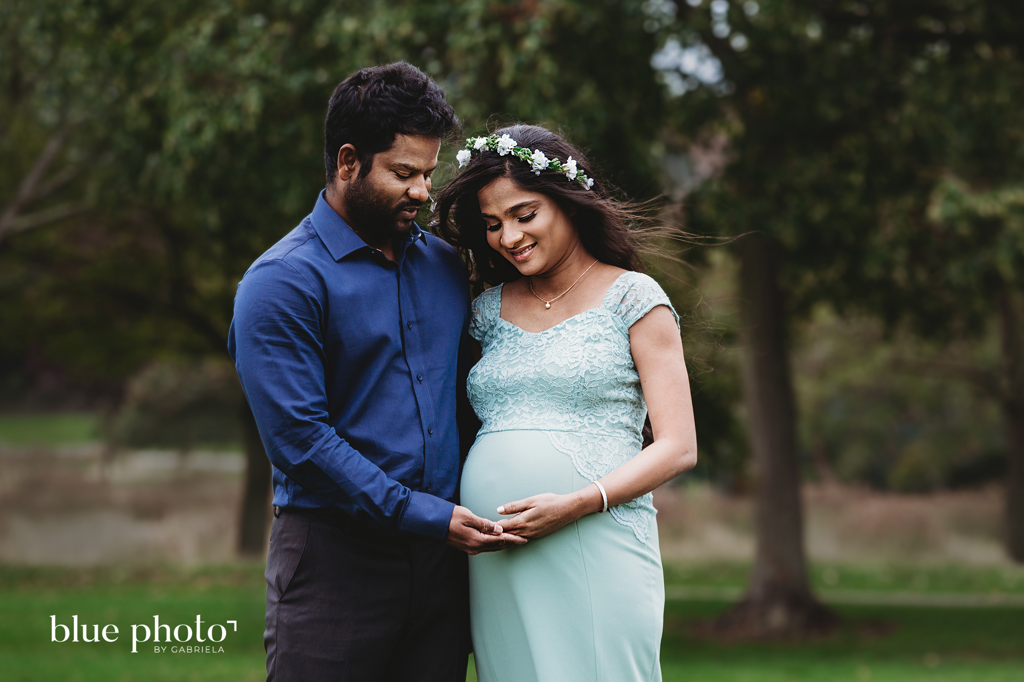 Socially distanced maternity session in West London. The couple is looking at the belly and smiling. 