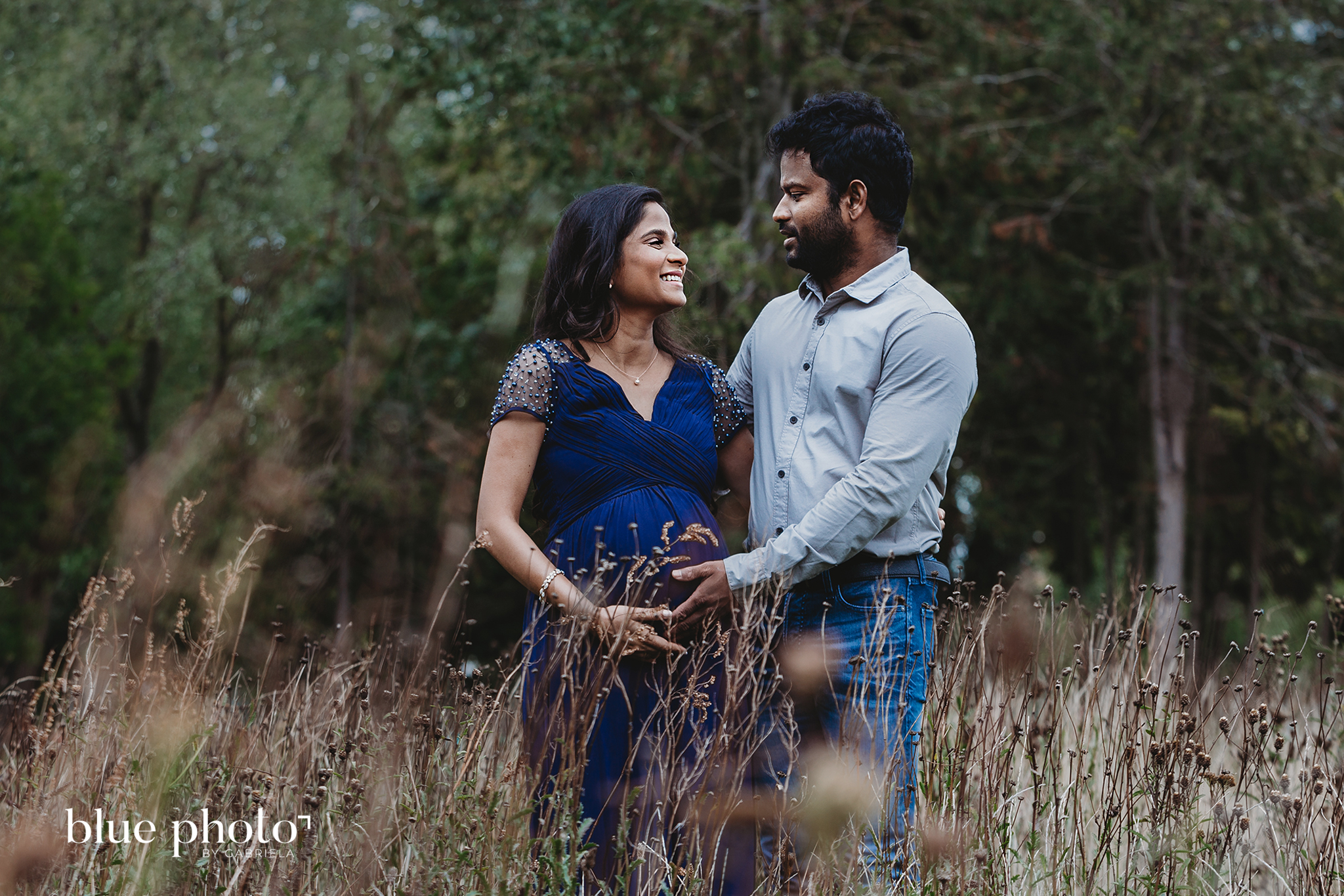 Socially distanced maternity session in West London. The couple is looking at each other and smiling. 