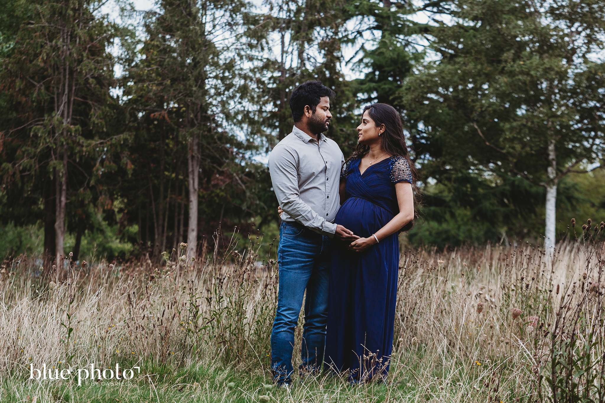 Socially distanced maternity session in West London. The couple is looking at each other and smiling. 